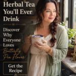 Woman holding a blue butterfly pea flower latte inside a modern farmhouse kitchen with botanical styling and warm natural light.