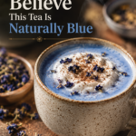 Close-up of creamy butterfly pea flower latte in a pottery mug.