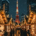 Roppongi Hills Christmas Market in Tokyo with glowing stalls and Tokyo Tower in the background.