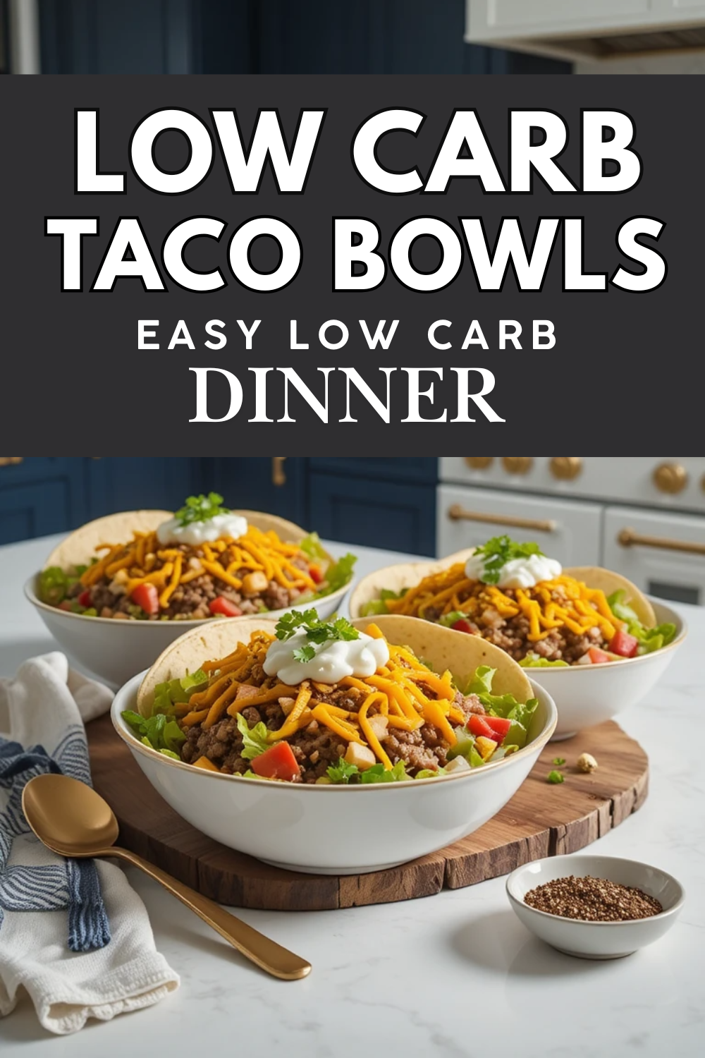 Easy keto taco bowls with beef, lettuce, shredded cheese, avocado, salsa, and sour cream in a white bowl on a marble-style countertop with dark blue kitchen cabinets in the background.