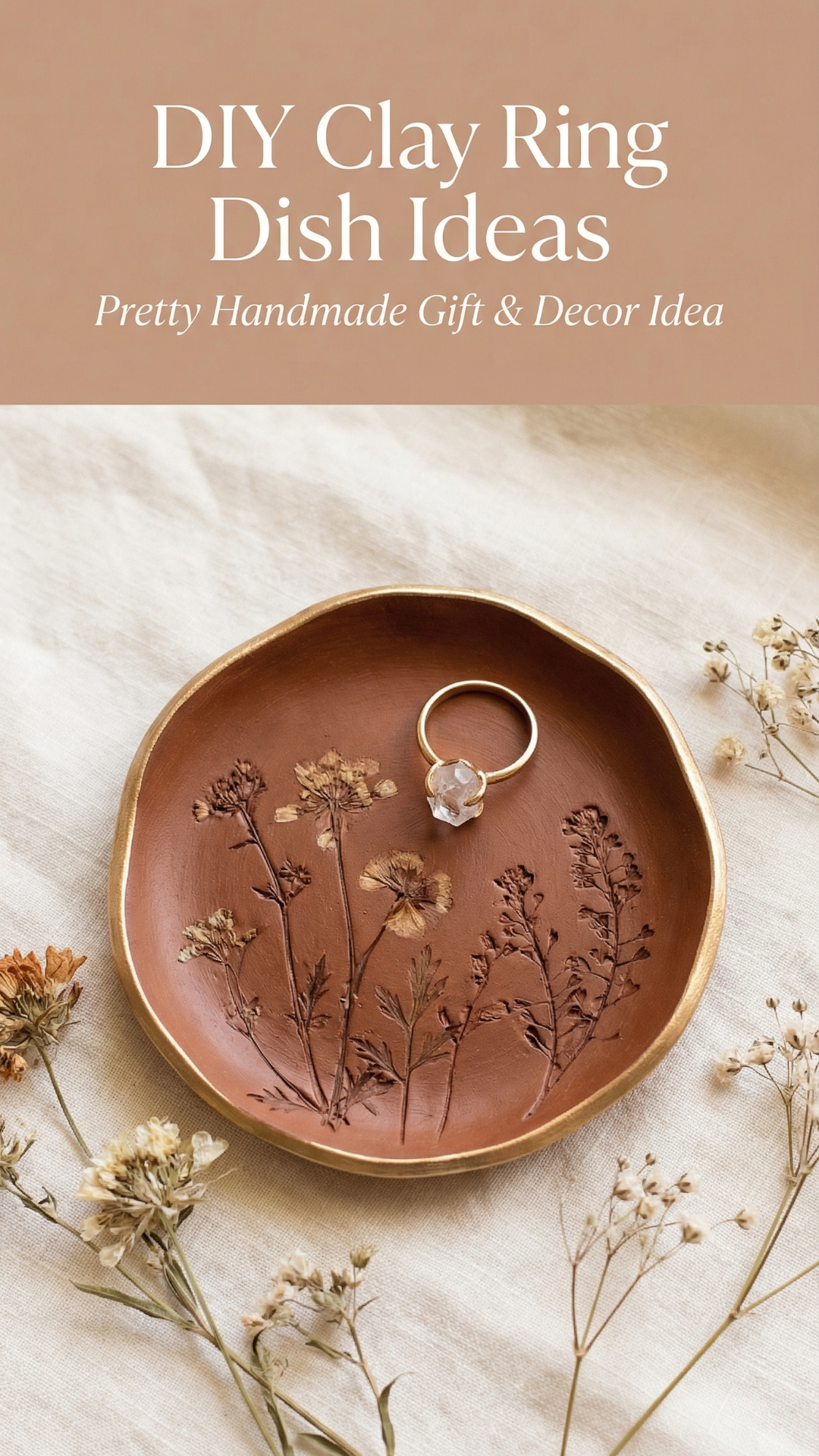 Terracotta clay jewelry dish with pressed botanical details and a gold ring, styled on soft neutral fabric.