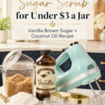Pinterest pin with text reading Homemade Sugar Scrub for Under $3 a Jar over a flat lay of vanilla extract, brown sugar jar, coconut oil, gold-lidded containers, and gold spoons on a white marble surface in a navy kitchen