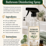 Clear glass trigger spray bottle labeled Bathroom Disinfecting Spray with eucalyptus branches, dried lavender, and cloves arranged on a white marble bathroom surface. Essential oil bathroom cleaning recipe by Aligned Design.