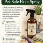 Amber glass trigger spray bottle labeled Pet-Safe Floor Spray with fresh lavender and sliced lemons on a light wood floor, with a vacuum cleaner and microfiber cloths in the background. Essential oil floor cleaning recipe by Aligned Design.