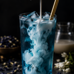 Tall glass of teal butterfly pea flower jasmine coconut cooler over ice with coconut milk cloud effect, dark moody background, scattered butterfly pea flowers and jasmine buds, teal aesthetic low carb drink