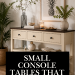 Cream two-tone console table with a wood top and black knob hardware, styled with a glass bud vase, stacked books, a lit candle, a framed pineapple print, and a small ceramic vase on the lower shelf.