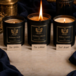 three burning matte black JD Aligned Design soy candles on a white quartz countertop beside an open burn test notebook and digital thermometer in a dark kitchen,