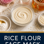 Overhead flat lay of rice flour face mask ingredients including flour, honey jar with dipper, rose water bottle, and pink peony on marble surface with navy and gold branded text overlay.