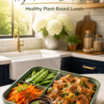 Plant-based tofu bento box with sesame tofu, carrots, snap peas, and dipping sauce.