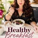 A woman with long dark hair in a dark top enjoys a spoonful from a bowl of yogurt topped with blackberry sauce at a bright farmhouse table with fresh flowers. Text overlay reads Healthy Breakfast That Feels Like Dessert.