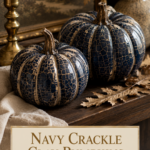Two navy crackle air dry clay pumpkins with cream crackle top layer and twig stems on a dark wood shelf