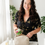 Woman packing a travel cosmetic bag with Korean skincare products in a bright, minimalist room. The image highlights travel-friendly K-beauty essentials for maintaining hydrated, healthy glass skin while traveling, including moisturizers, serums, and skincare treatments.