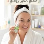 Pinterest pin featuring a woman in a white spa robe holding a Korean serum in a bright bathroom. The text reads "Calm Redness for a Glass Skin Glow." The image promotes soothing Korean skincare products for sensitive skin, redness relief, hydration, and achieving healthy, radiant glass skin.