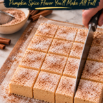 A slab of homemade low carb pumpkin spice marshmallows on parchment over a wooden cutting board, being sliced into neat cinnamon-dusted squares with a large knife, next to a bowl of spiced dusting powder with a small sifter, cinnamon sticks, an orange pumpkin and a blue plaid kitchen towel.